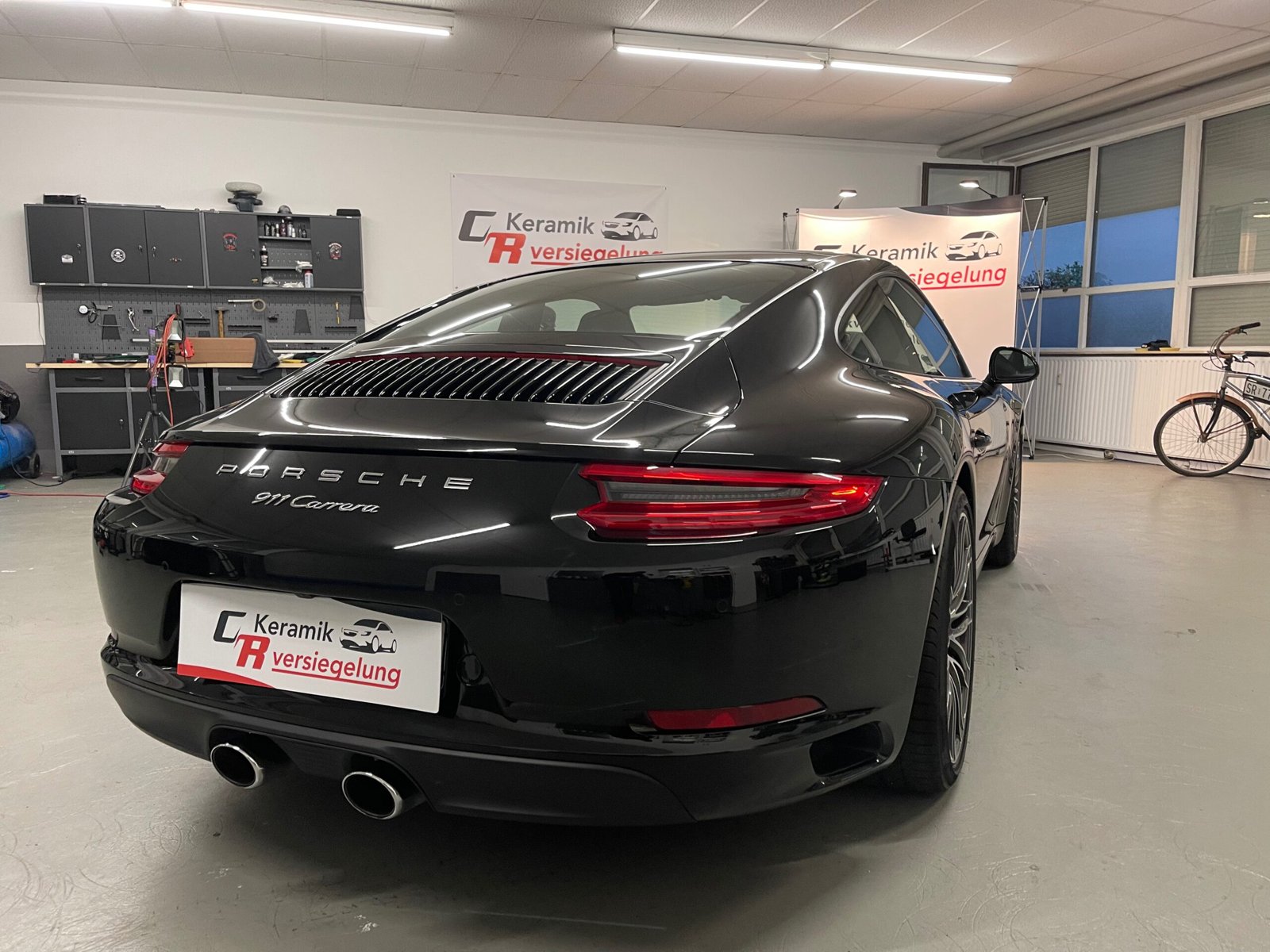 Schwarzer Porsche 911 Carrera in der Werkstatt