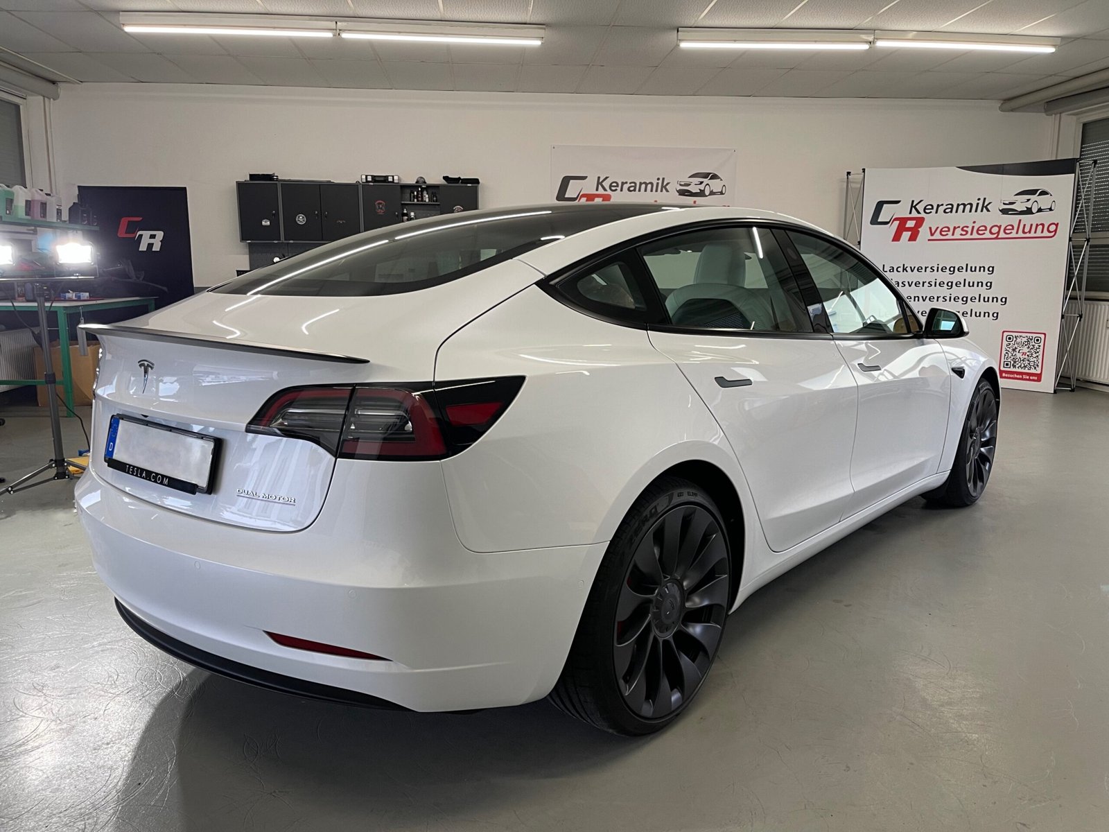 Weißer Tesla Model 3 in der Werkstatt